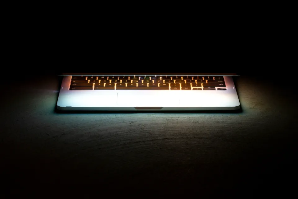 Teclado retroiluminado de un portátil encendido en la oscuridad